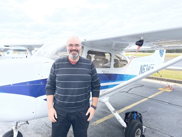 Tim standing next to an airplane